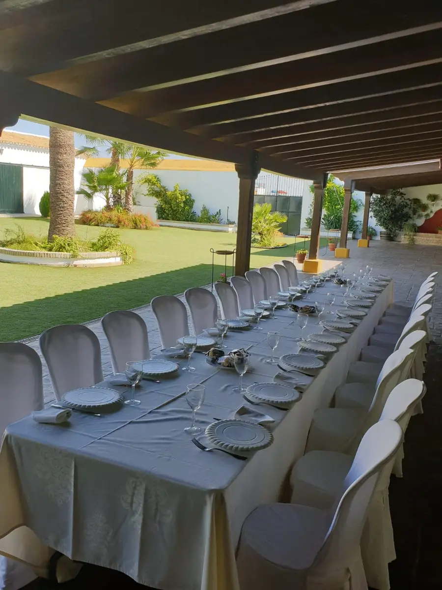 mesa larga banquete bajo pergola vista jardin