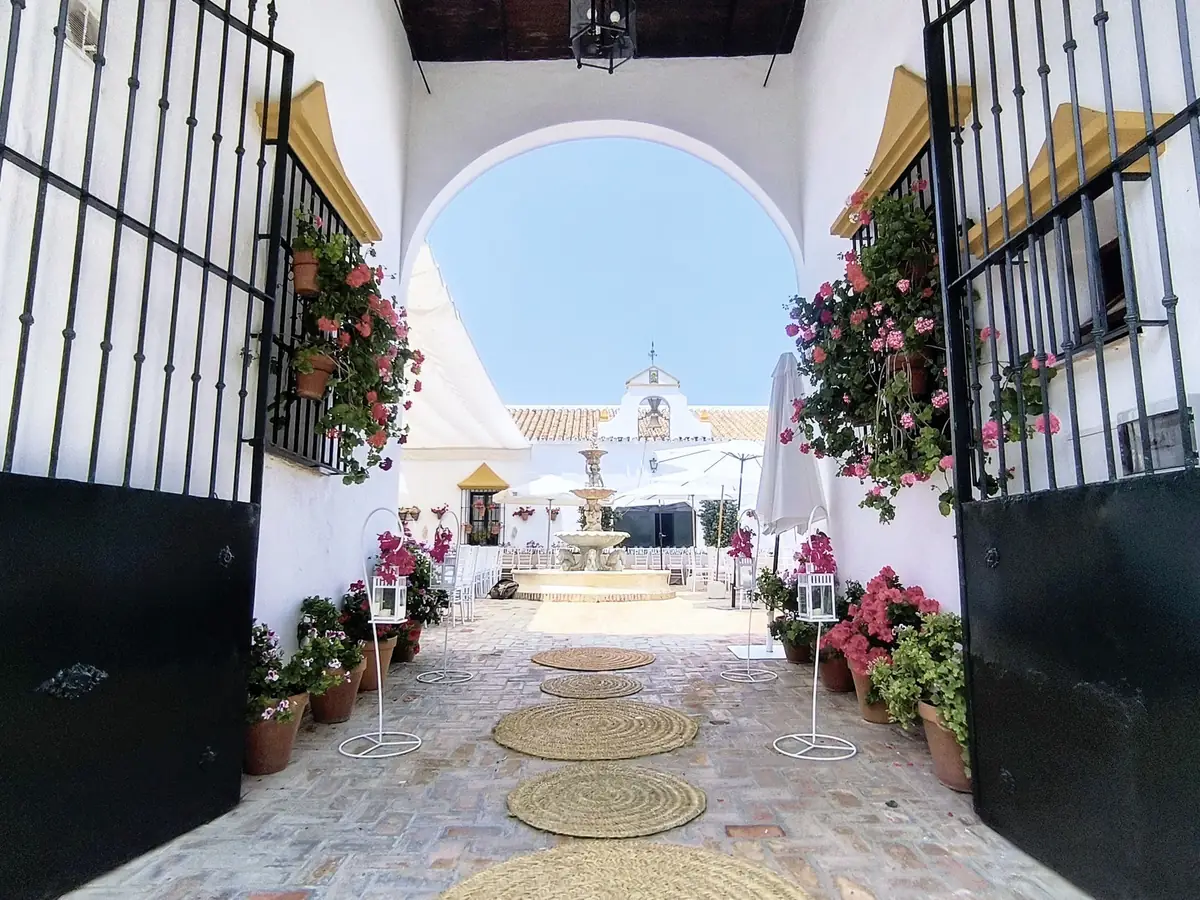entrada arco patio fuente alfombras esparto